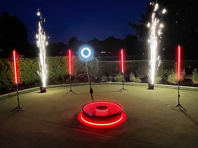 Two Cold Spark units firing beside a red-lit 360 platform at an outdoor setup